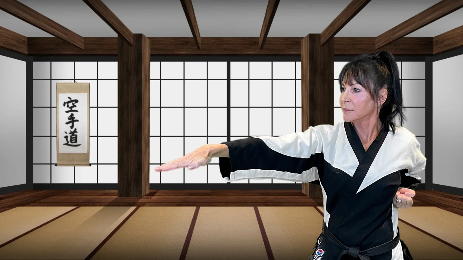 Jan, wearing a black belt and gi, performs a focused martial arts block in a dojo featuring tatami mats and shoji screens.